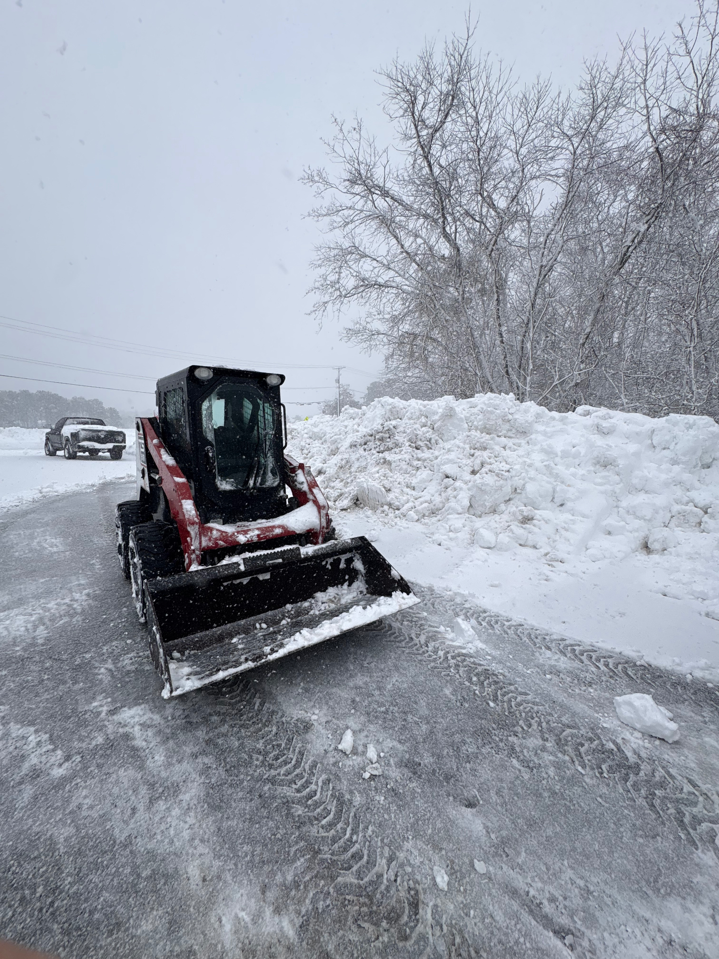 Commercial snow removal skid steer clearing a commercial parking lot in Barnegat, Ocean County, New Jersey